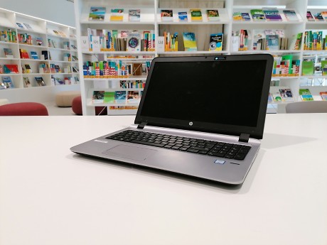 Laptop auf einem Tisch, im Hintergrund Bücherregale Quelle: Stadtbibliothek Rottenburg