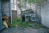 Verlassenes Gebäude mit alten Möbeln, welches schon von Pflanzen zurückerobert wird.
