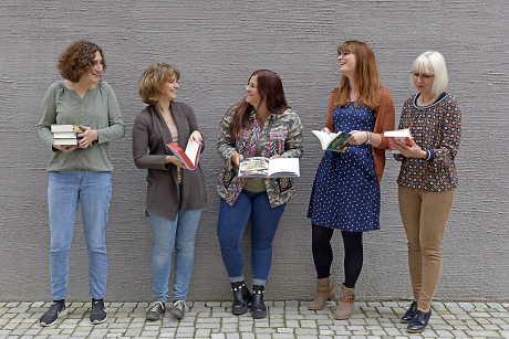 5 Frauen vor einer grauen Fassade, sie lachen und unterhalten sich Quelle: Stadtbibliothek Rottenburg am Neckar