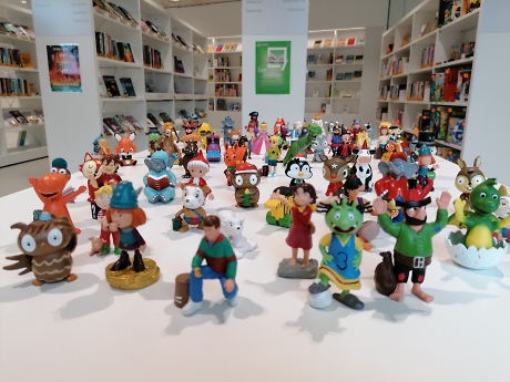 Spielefiguren bunt, im Hintergrund Buchregal Quelle: Stadtbibliothek Rottenburg