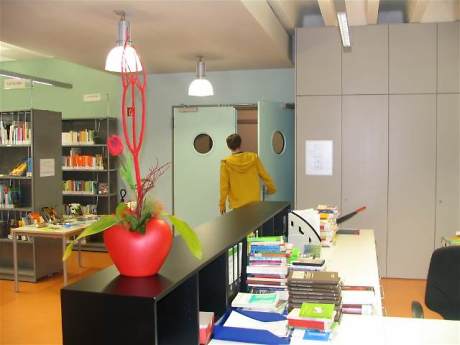 Empfangstheke in einer Bücherei, im Hintergrund geht jemand durch eine Tür nach draußen Quelle: Mediothek am Eugen-Bolz-Gymnasium